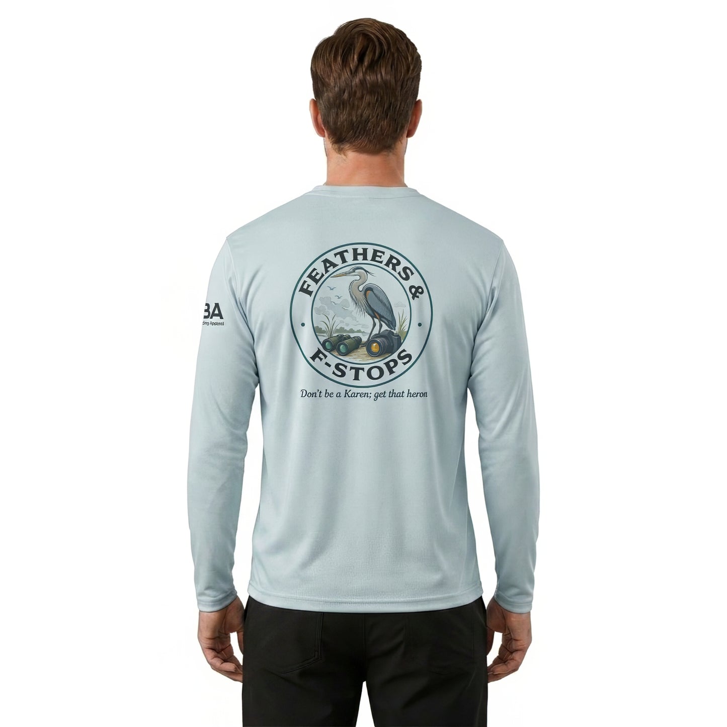 A man viewed from the back wearing a light blue long-sleeve performance shirt with a large circular graphic on the back featuring a heron and the text 'FEATHERS & F STOPS' and 'Don't be a Kareo, get that farm.'.