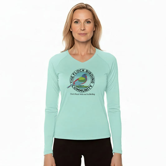 Woman wearing a light blue long-sleeve shirt with a bird-themed logo on a white background
