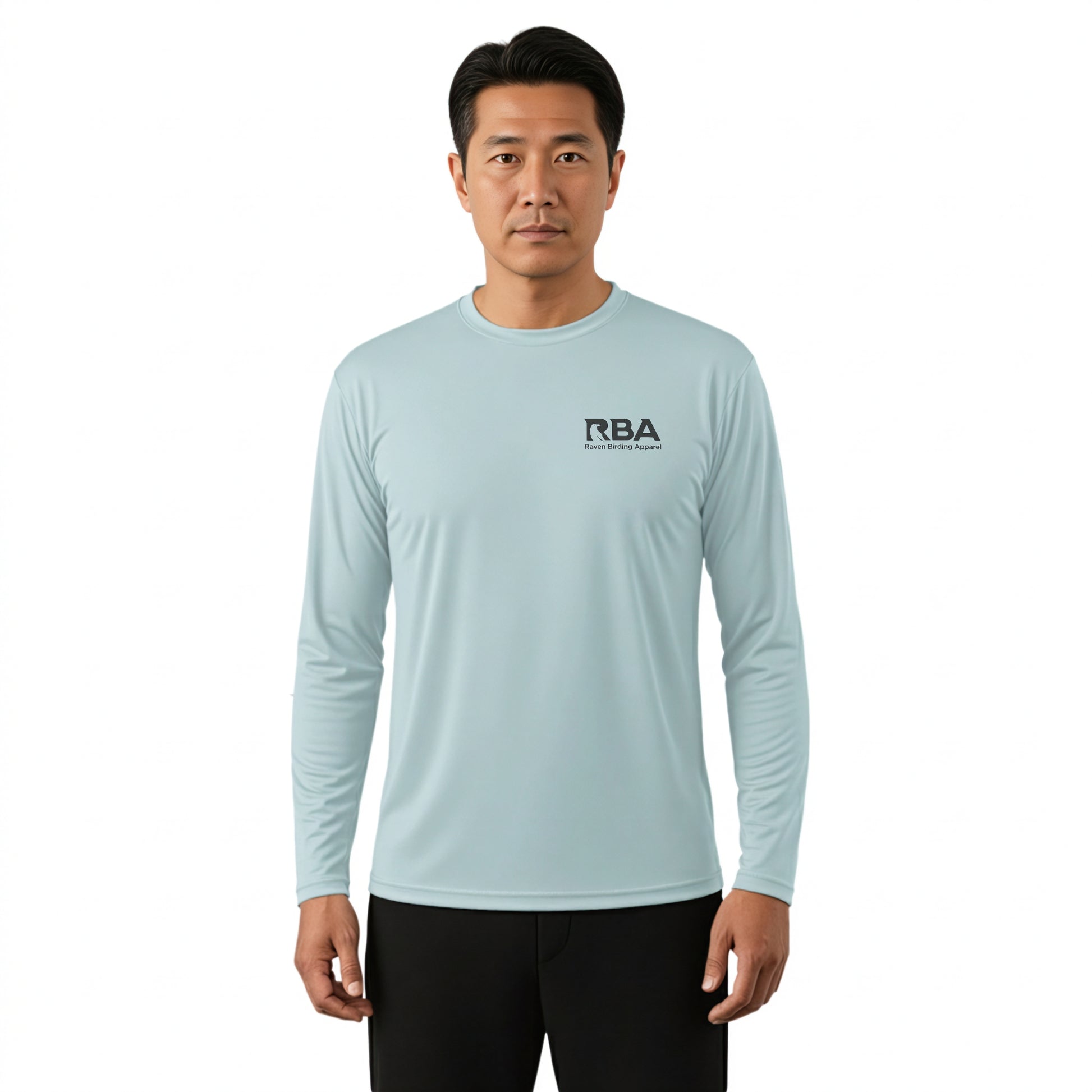 A man wearing a light blue long-sleeve athletic shirt with a black RBA logo on the left chest, paired with black pants, against a plain white background.