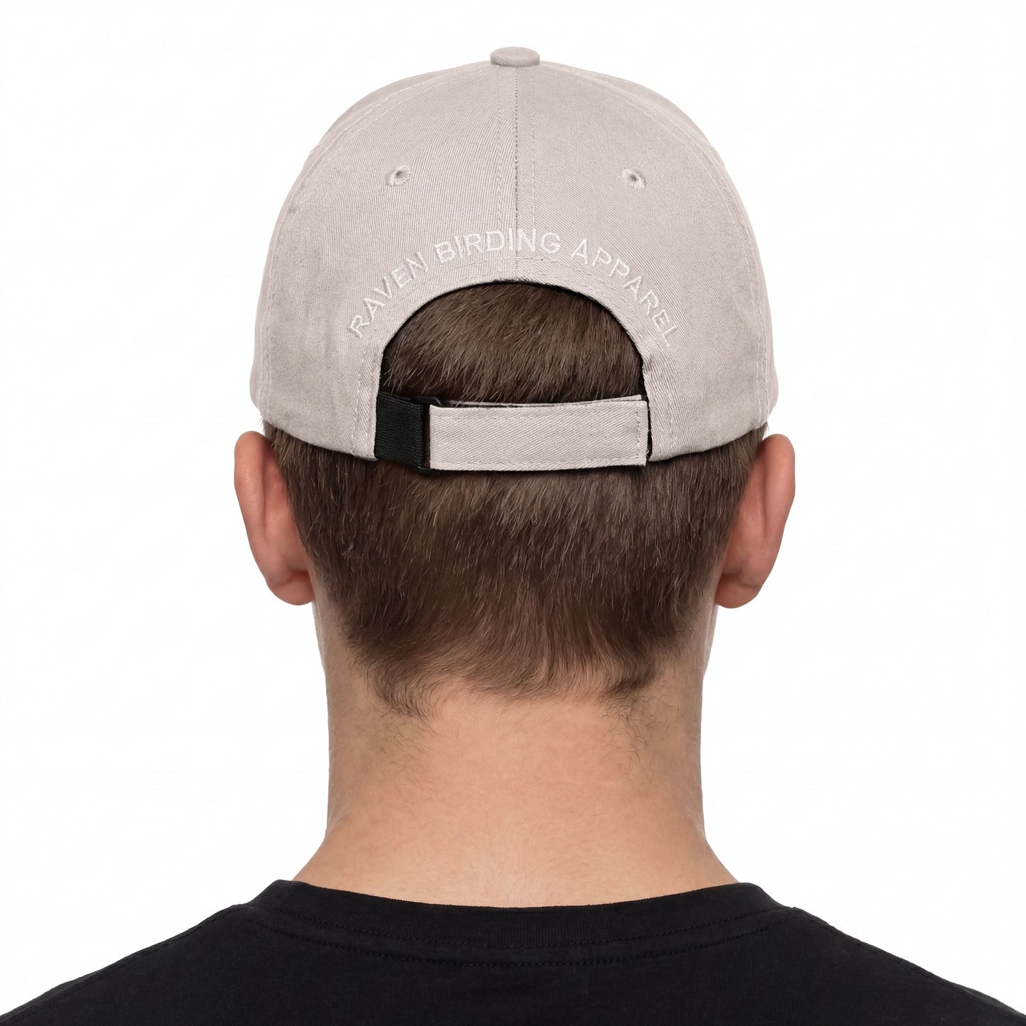 Person wearing a gray cap with 'Raven Birding Apparel' branding on a white background