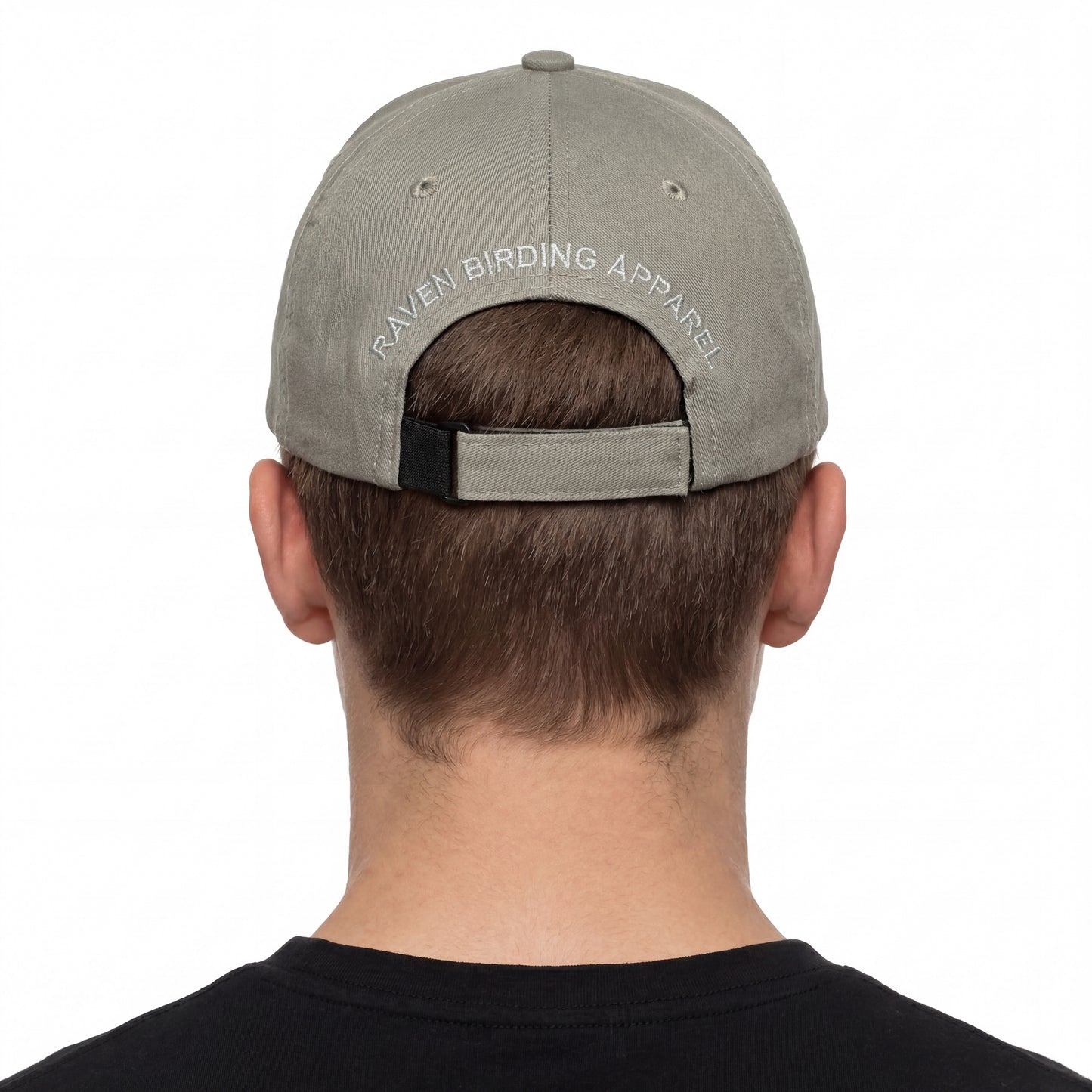 Person wearing a gray cap with 'Raven Birding Apparel' logo on a white background