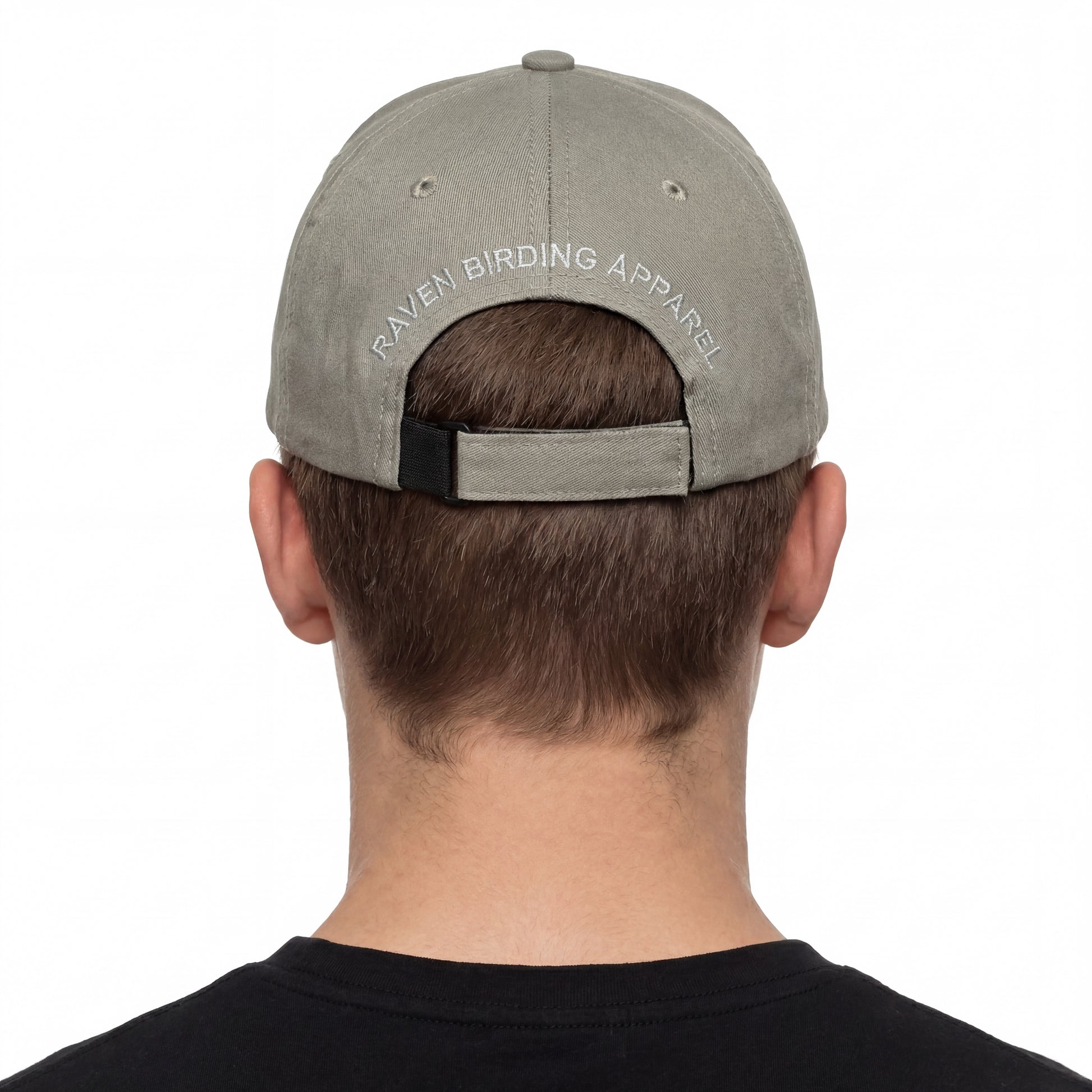 Person wearing a gray cap with 'Raven Birding Apparel' logo on a white background