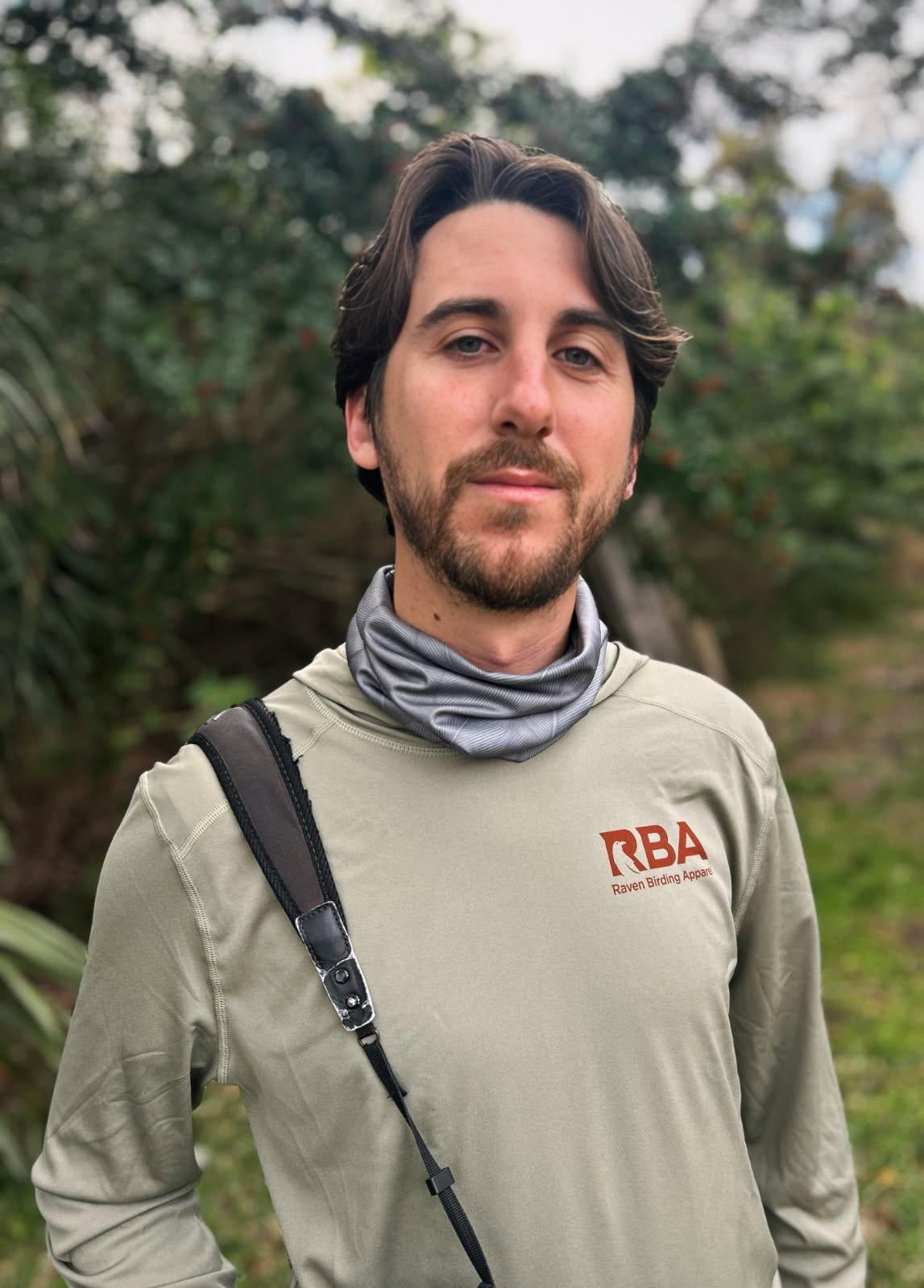 Man wearing an olive shirt with RBA logo outdoors